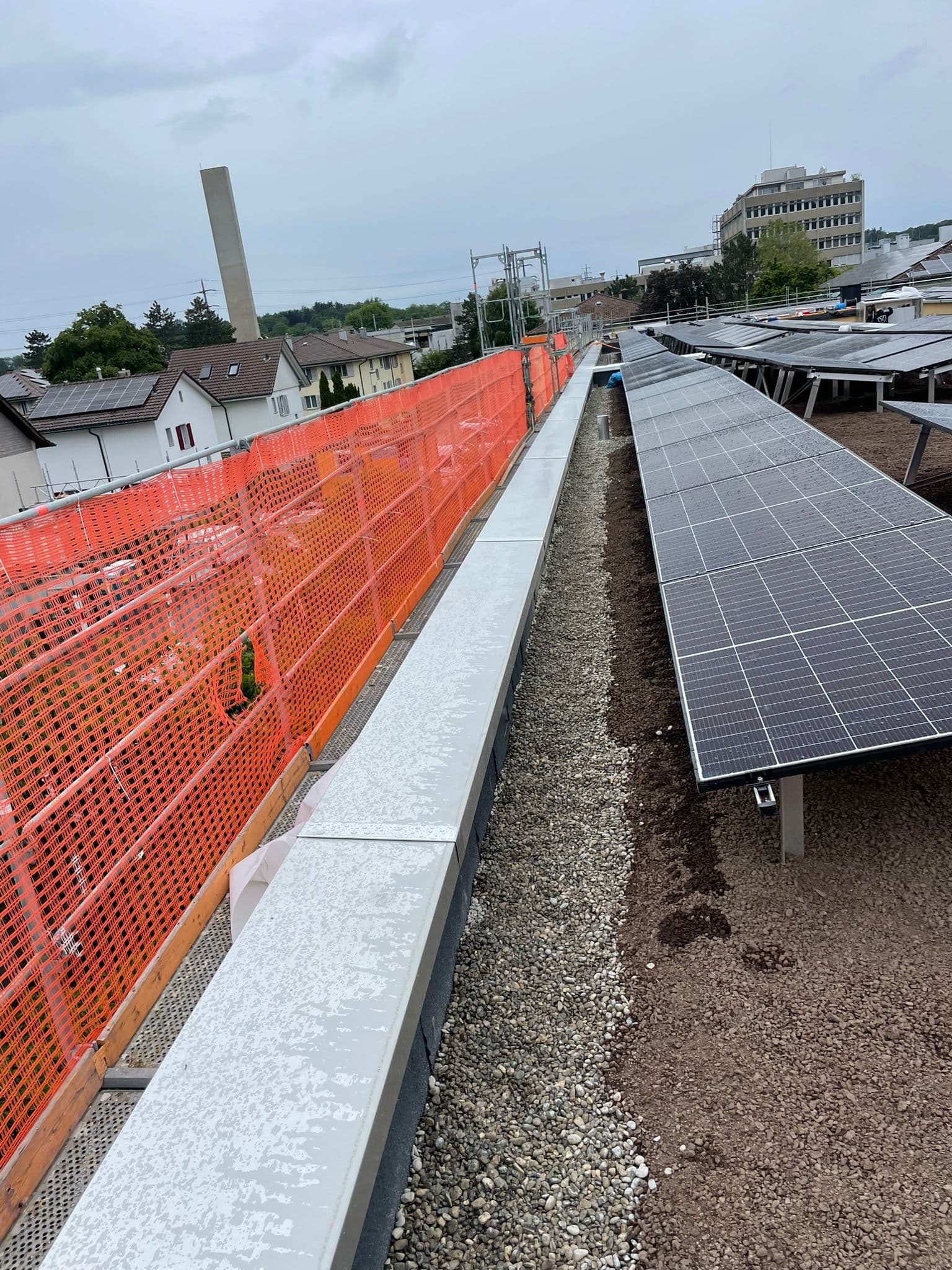 Flachdach mit aufgeständerter PV-Anlage und Aluminium-Attika