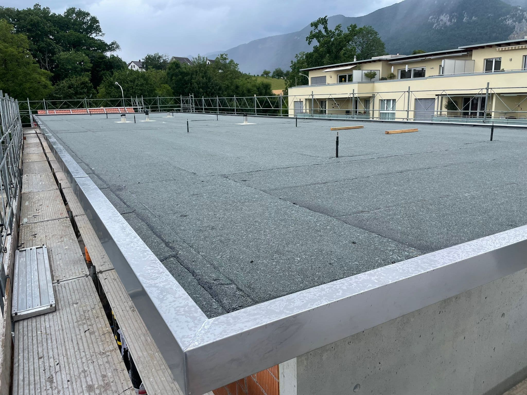 Frisch verlegtes Flachdach mit Aluminium-Attika und Voralpenpanorama