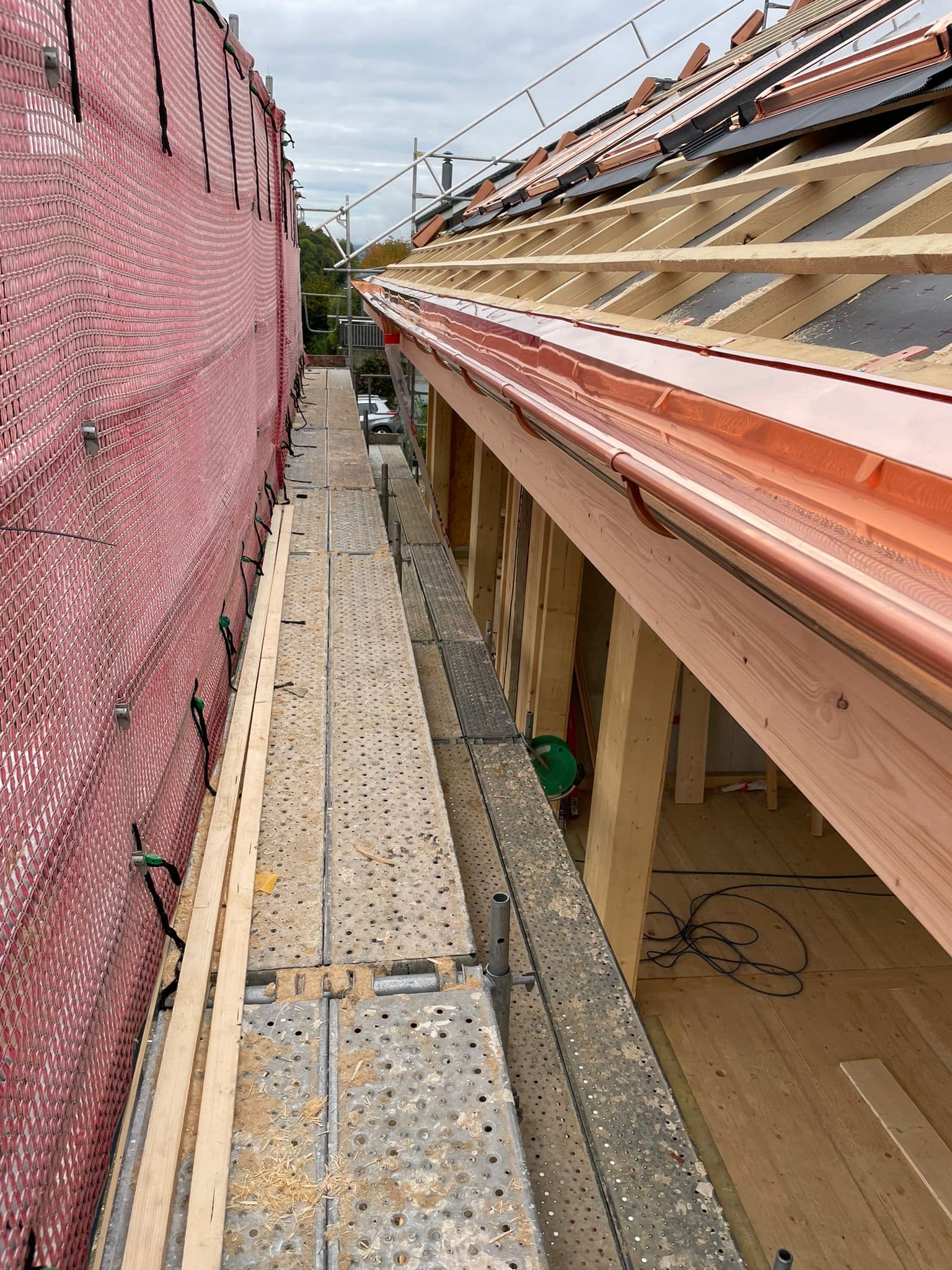Kupferrinne an Holzbau-Neubau mit sichtbarer Sparrenkonstruktion