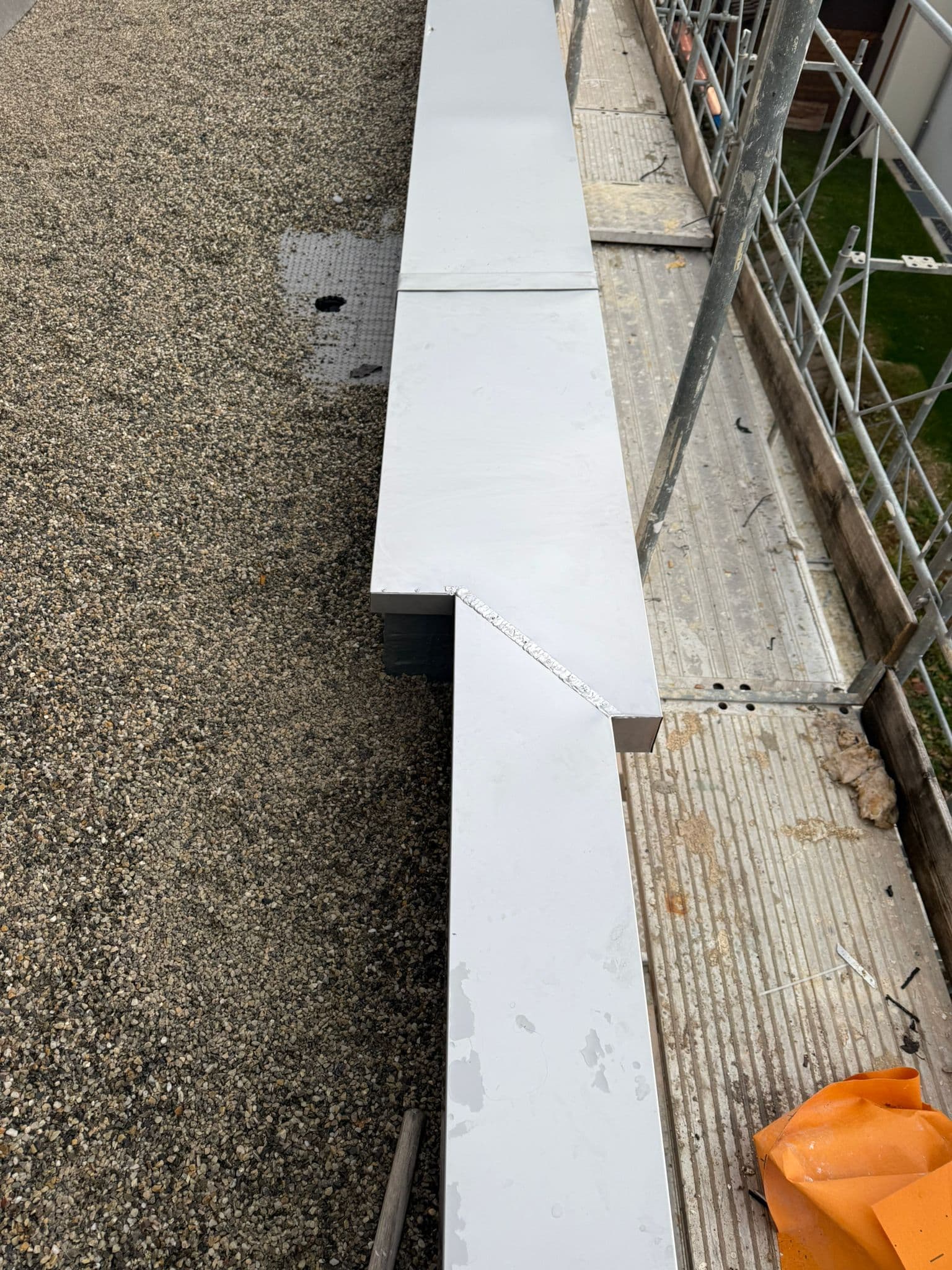 Industrieflachdach mit Aluminium-Attikaverblechungen über Kiesschüttung