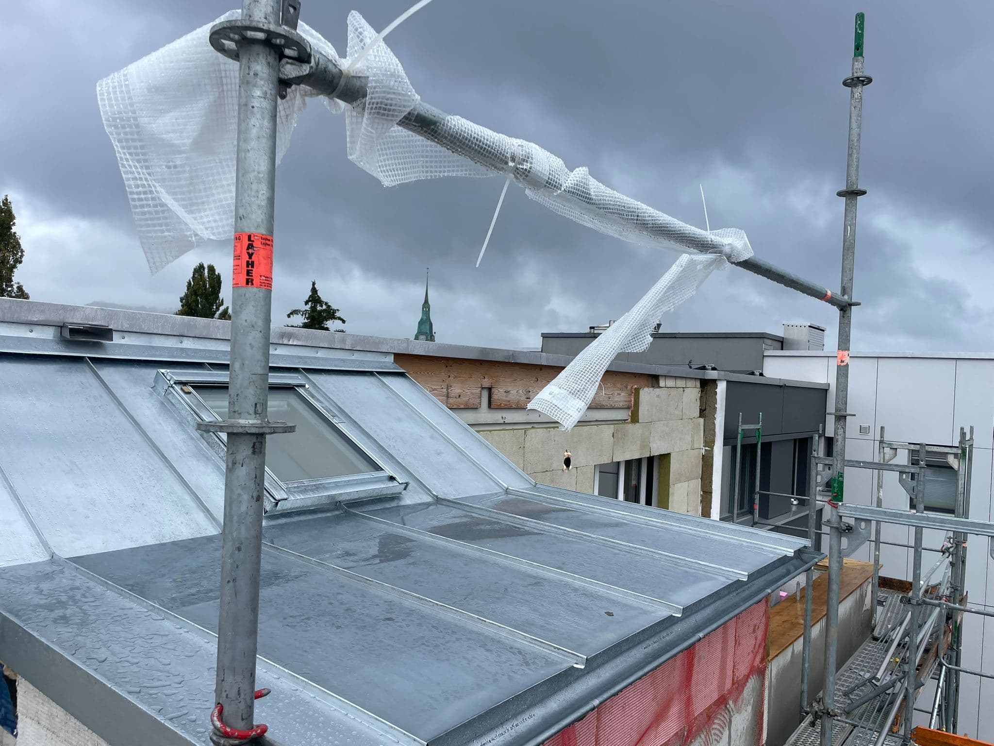 Galvanisiertes Stehfalzdach im Sturm während Werkmontage